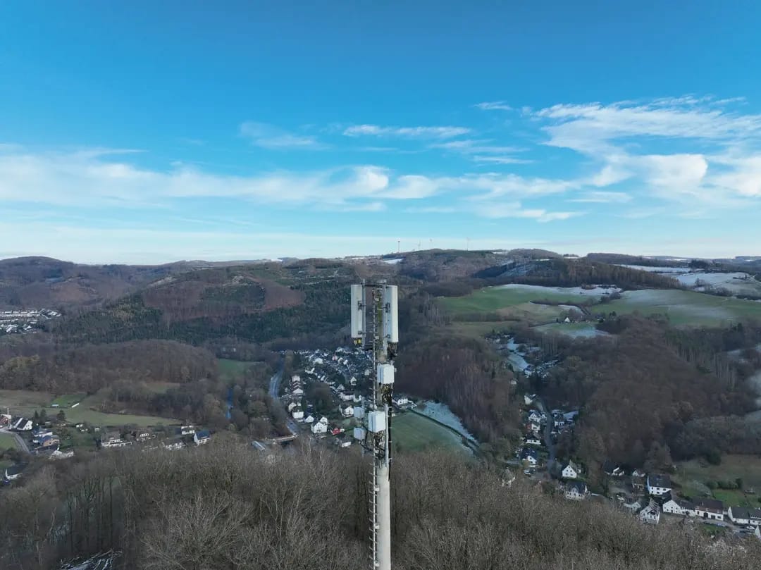 Funkmast und weitläufige Landschaft aus der Luft bei Tag